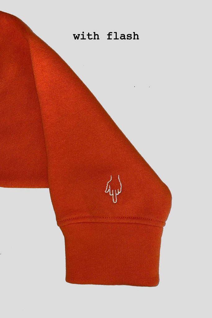 Orange cotton hoodie with reflective embroidery. 